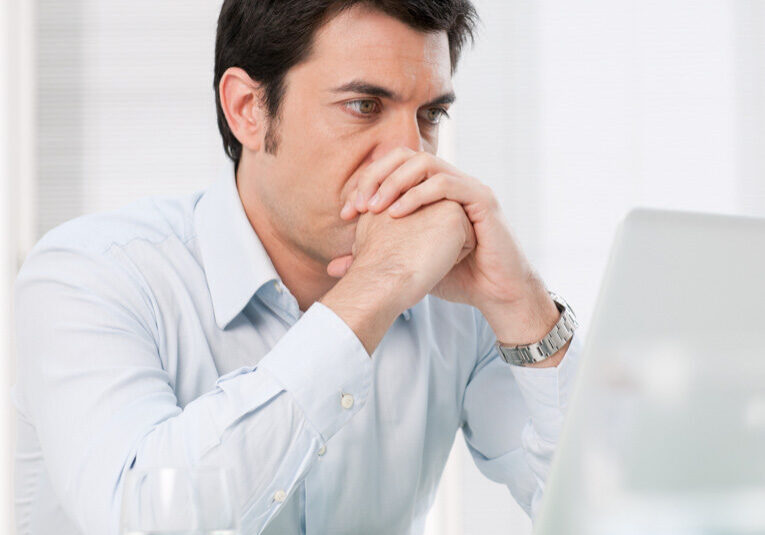 Pensive man at laptop Man struggling with Imposter syndrome
